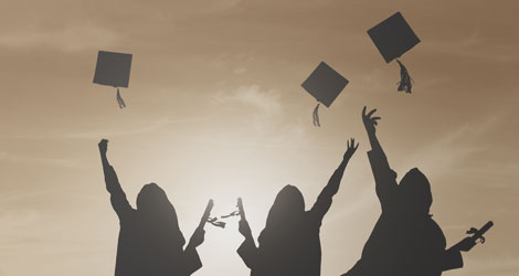 Absolventen werfen ihre Doktorhüte in die Luft